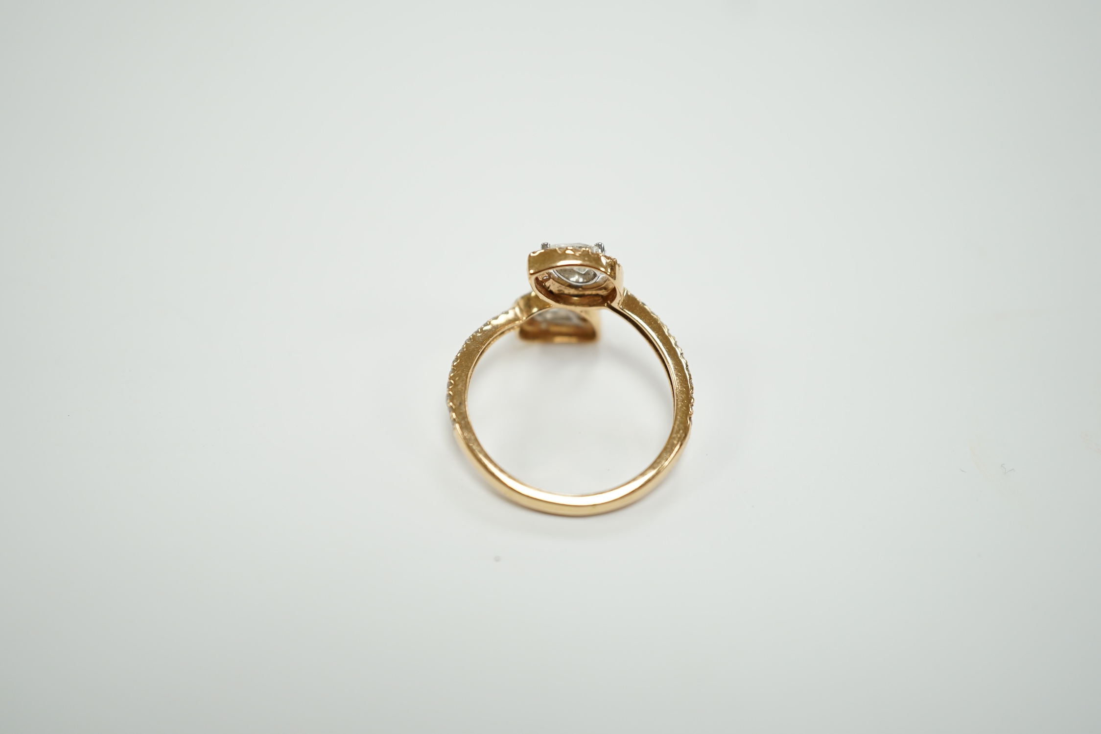 A modern 18k and two stone pear cut diamond set cross-over ring, with diamond chip border and shoulders, size L, gross weight, 2.9 grams.